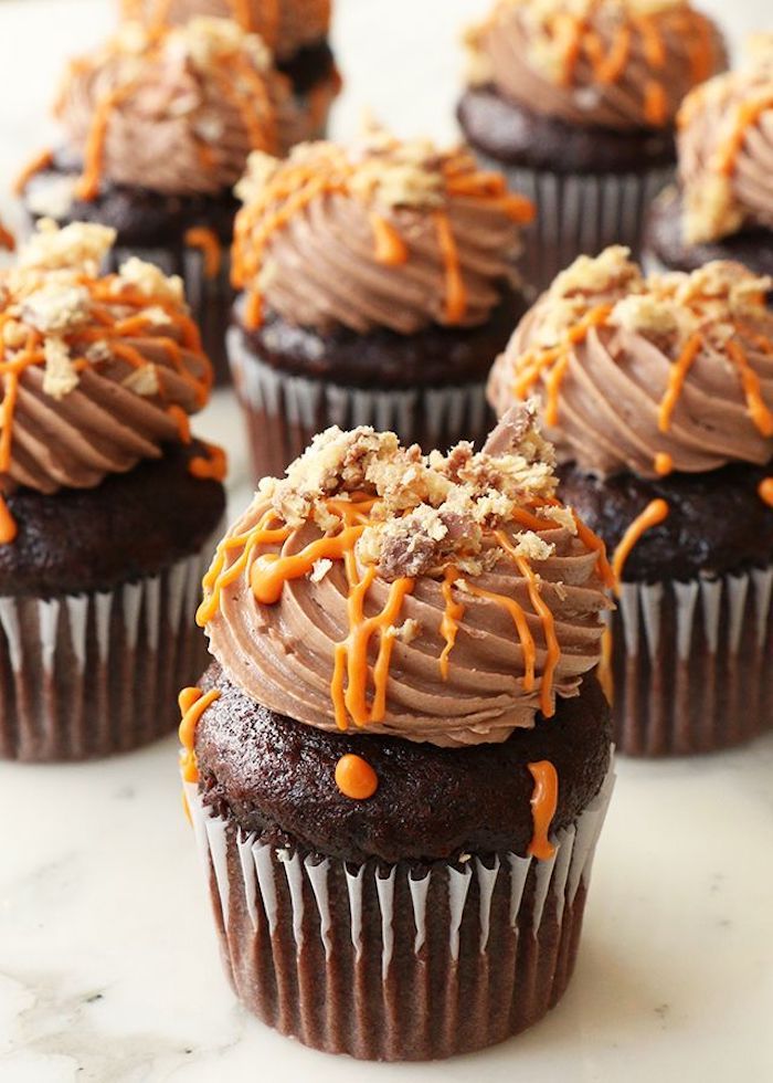 Halloween muffins med choklad dekorerad med kräm och orange smörgås