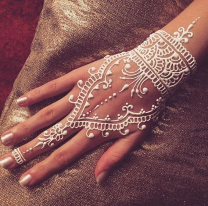 Tatuaż dla nowożeńców z białą henną, tatuażem po środkowym palcu, powierzchnią dłoni i tatuażem na nadgarstku w kolorze białym