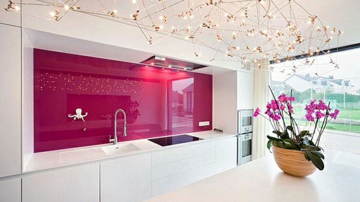 elegancka kuchnia z białymi szafkami i różową tylną ścianą kuchni