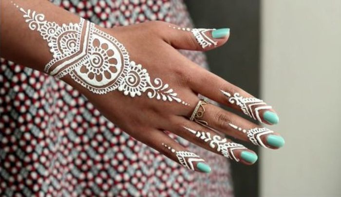 Colore henné: henné bianco, donna con vestito colorato con tatuaggio sul dito e tatuaggio sul polso