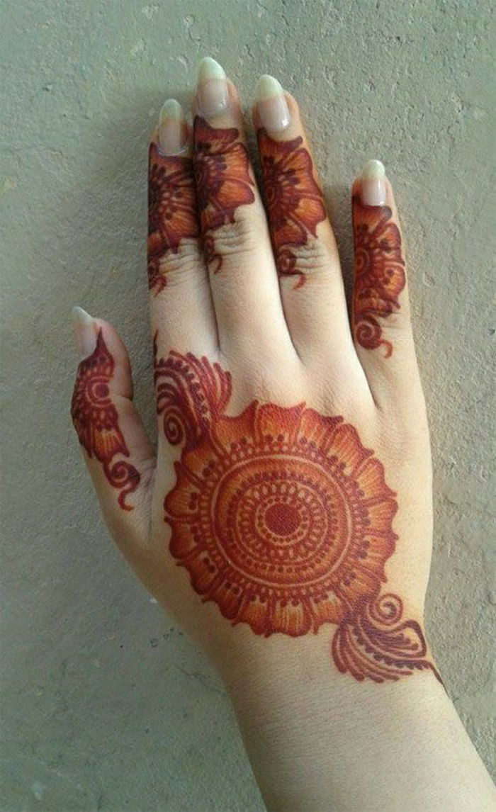 tymczasowy czerwony tatuaż henny na powierzchni dłoni kobiety o długich paznokciach, kwiatowych tatuażach