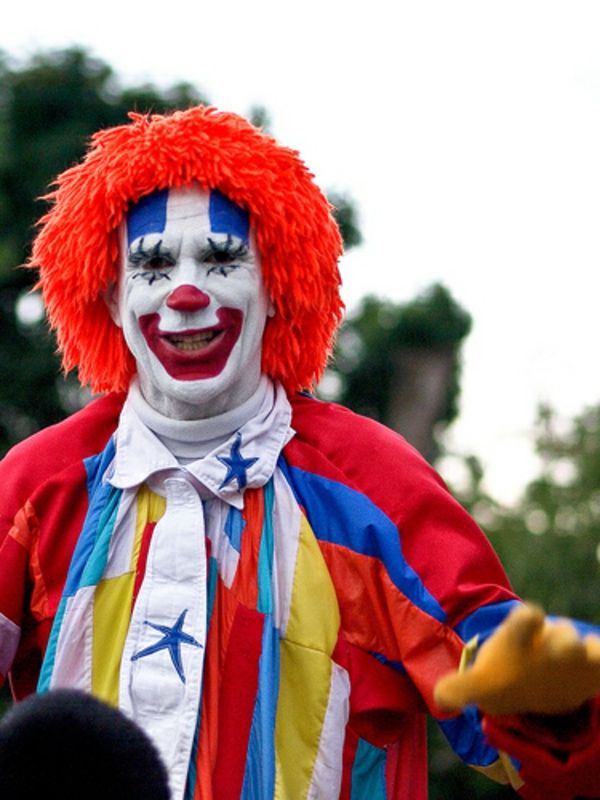 clown ansikte målning - rolig utseende av en man - med en orange peruk