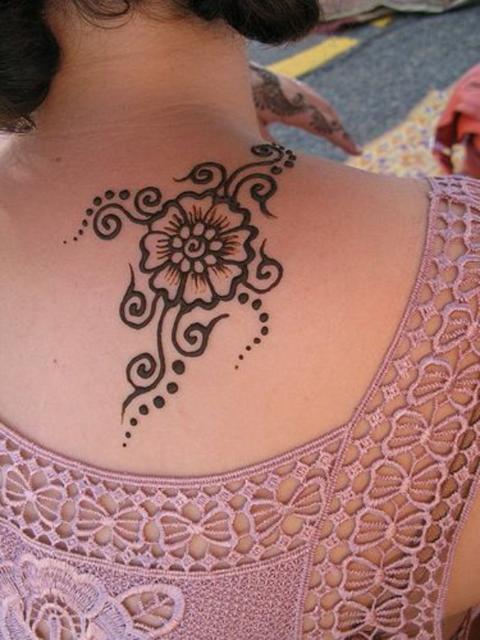 žena s ružovou topou z čipky s popruhmi, zadné tetovanie s čiernou a hnedou farbou henny