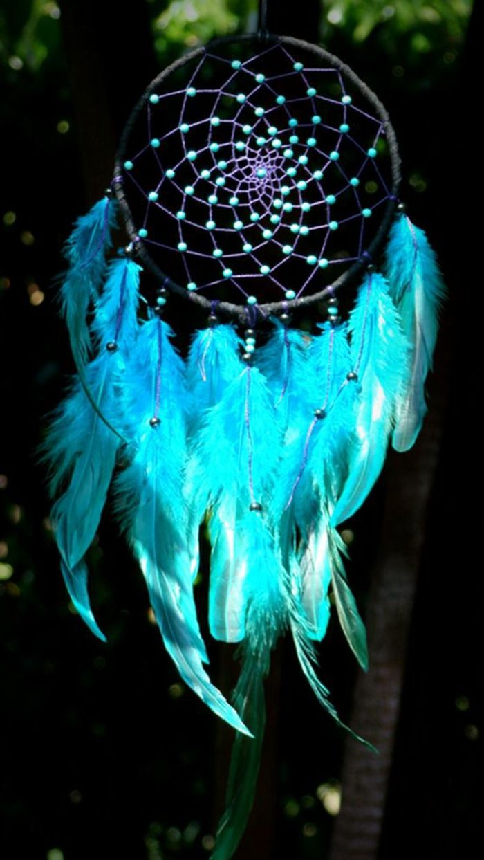 en svart drömfångare med flätat ljusblå träpärlor