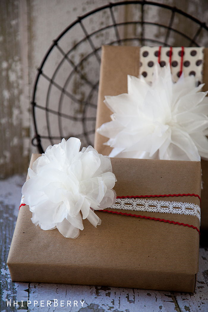 dva zabalené darčeky zdobené bielymi kvetmi a čipkou