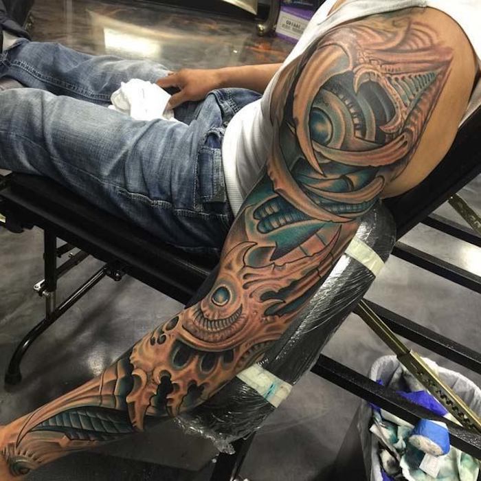 Biomechanica-tatoeage over de hele arm, man met biomechanische tatoeage