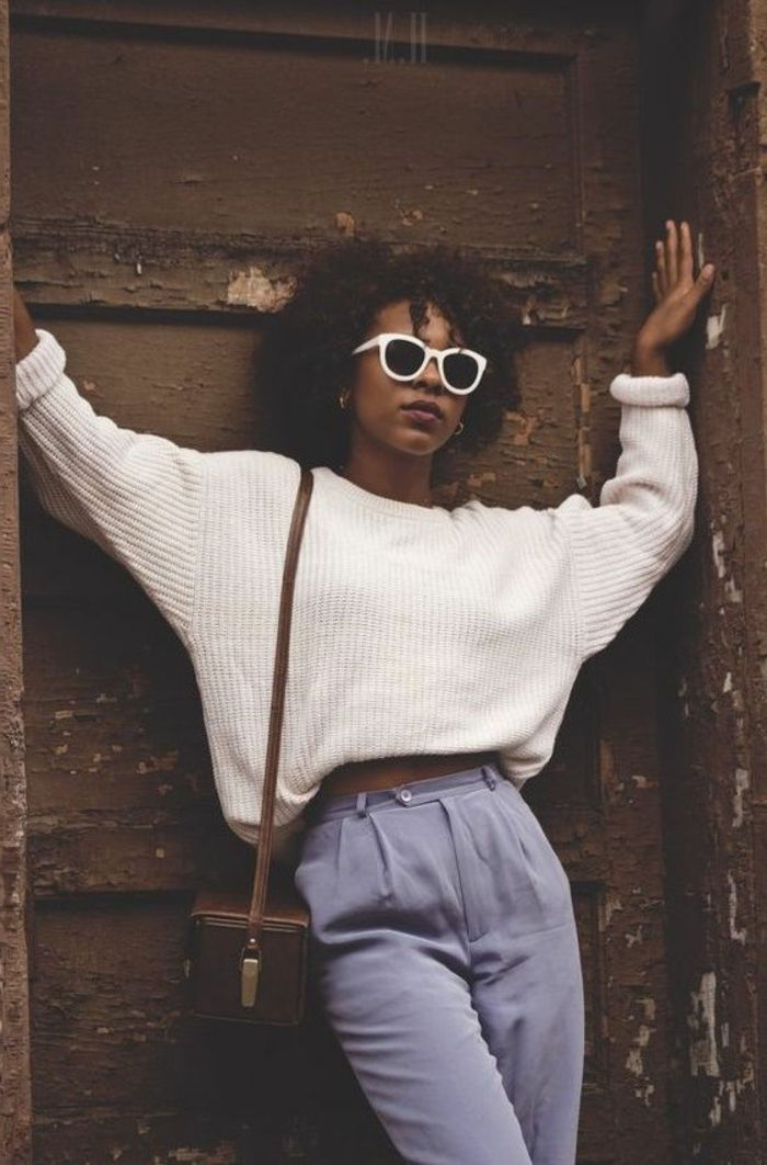 80年代の女性服 - パステルカラーのハイウエストパンツ、白いオーバーサイズのセーター、ブラウンレザーバッグ、ホワイトサングラス