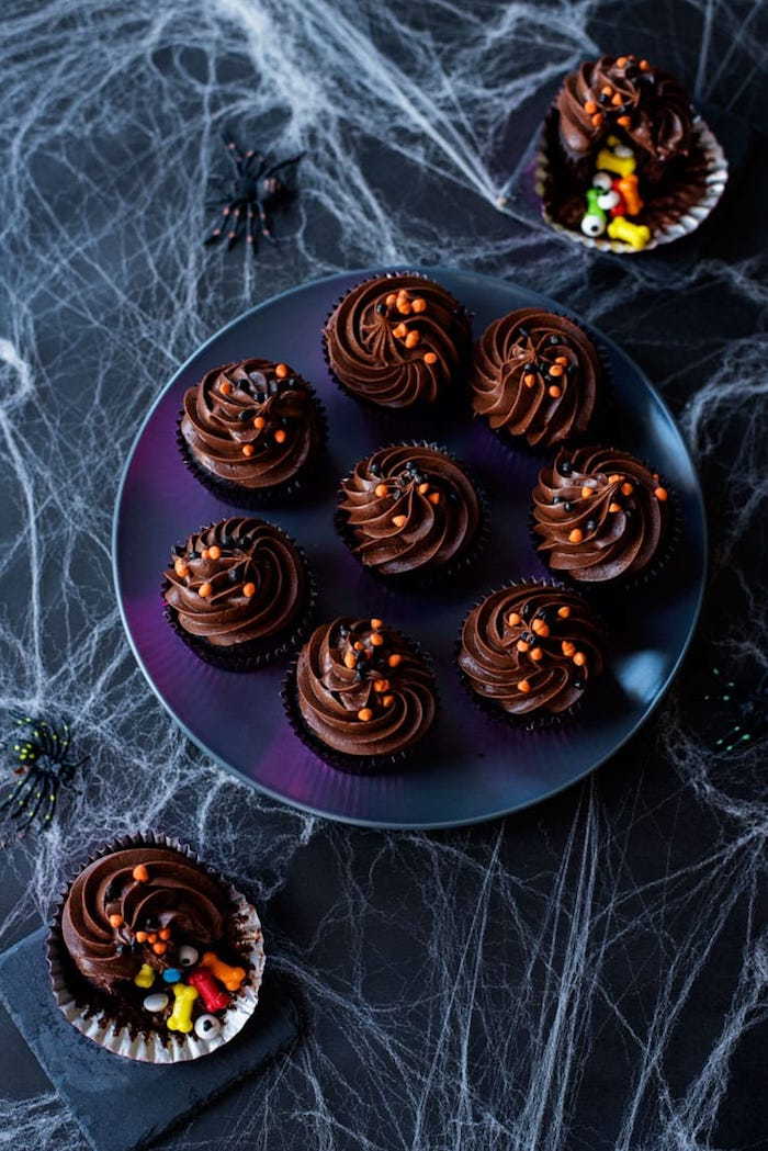 decorando muffins, cupcakes de chocolate decorados com creme e granulado