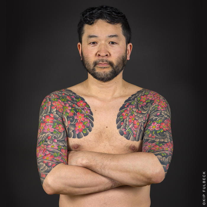 Tatuaje japoneze, om cu tatuaje mari, cu valuri de apa si flori de cires