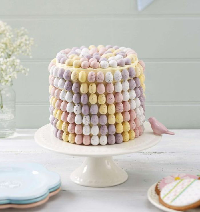 Motivna torta, okrašena z velikonočnimi jajci, postavljena na precej torto