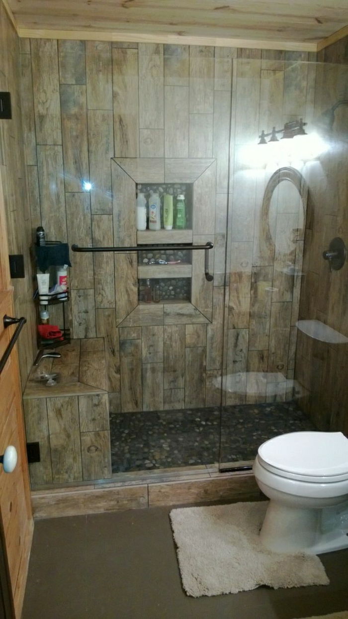 Casa de banho chuveiro, de estilo rústico, pedras decorativas chão de madeira
