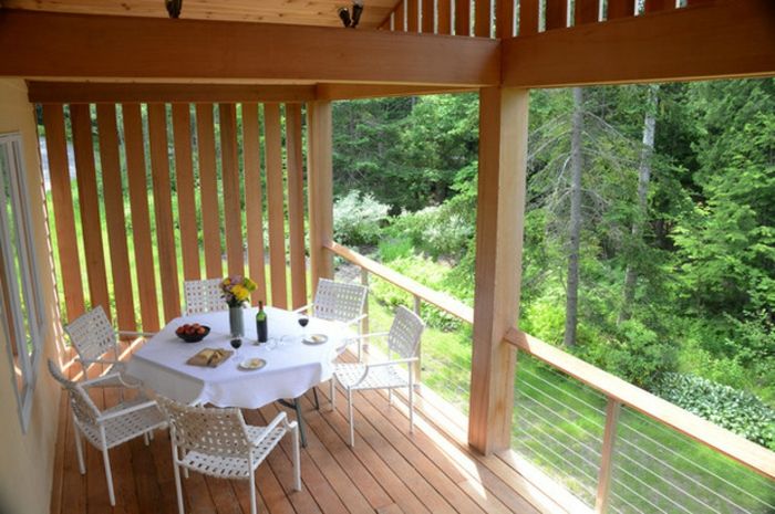 Trä balkong och terrass trägolv runt matbord med stolar