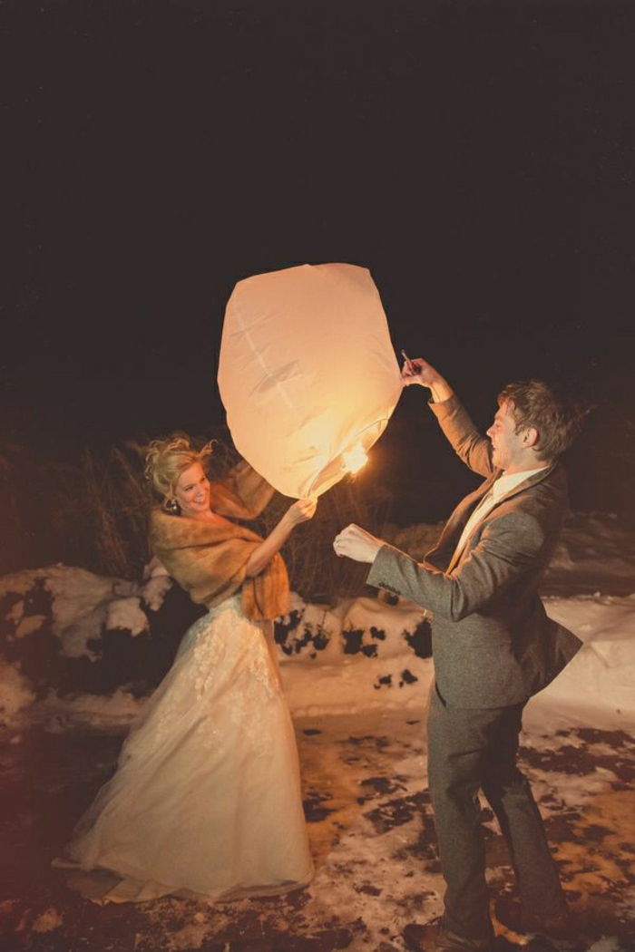 Poročni par, ki plujejo luči snega Zima