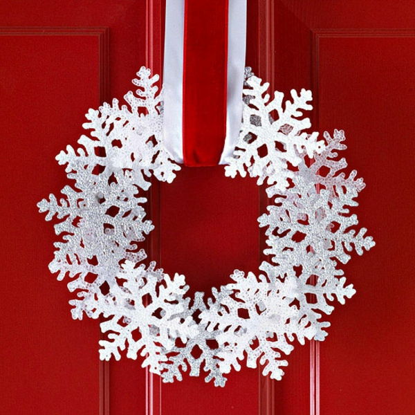 vit juldekoration - röd dörr och en vit krans på den