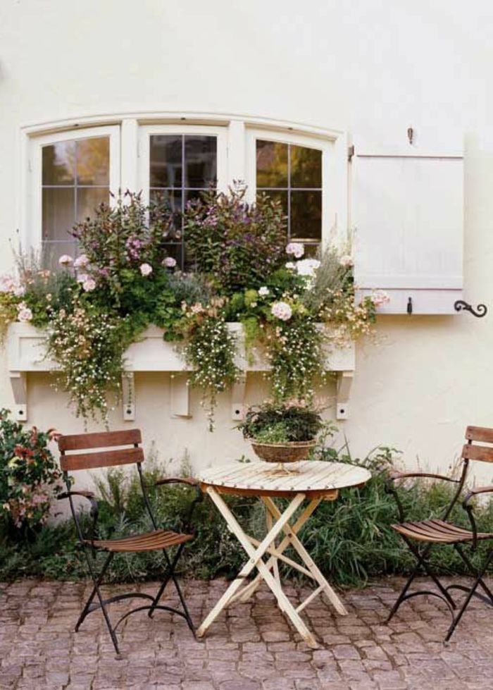 Giardino tavolo e sedie in ferro battuto molti vasi di fiori di scatto legno bianco