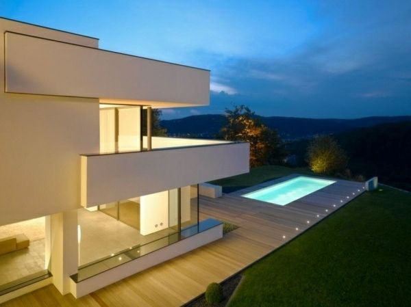 Zijkant terrassen en glazen wanden in het moderne huis met een witte gevel