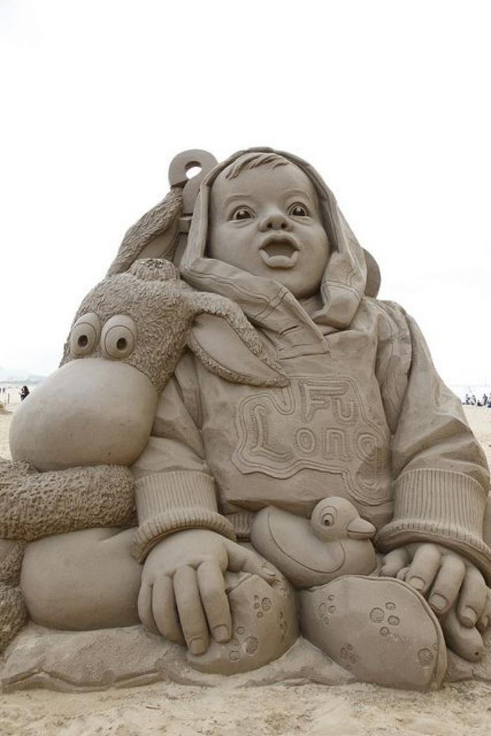 Art skulptur fra sand-barn med-hans-leker