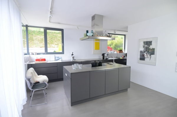 Kuhinja iz kuhinje v sivi kuhinji, ki je narejena po meri, z belimi zavesami