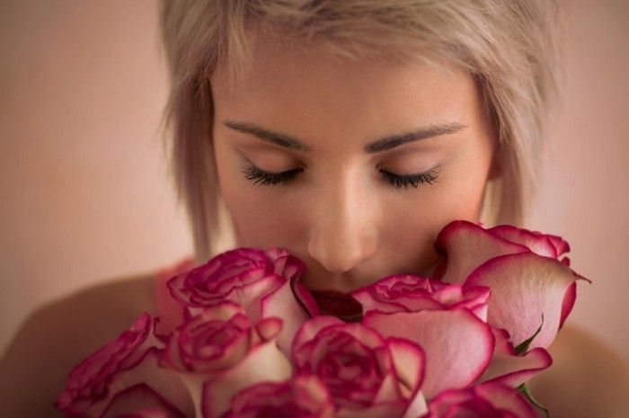 Jauna graži moteris, turinti rožinių rožių puokštę. Ji labai patenkinta. Valentino's day or international women's day celebration.