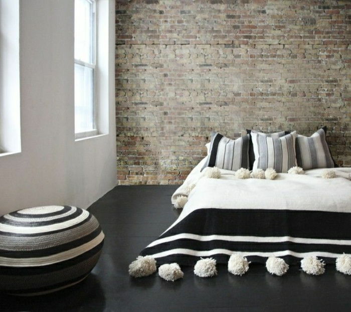Spálňa tehlové múry minimalistický setup-marocký-Pom-Pom-prehoz-čierno-bielo-šedý
