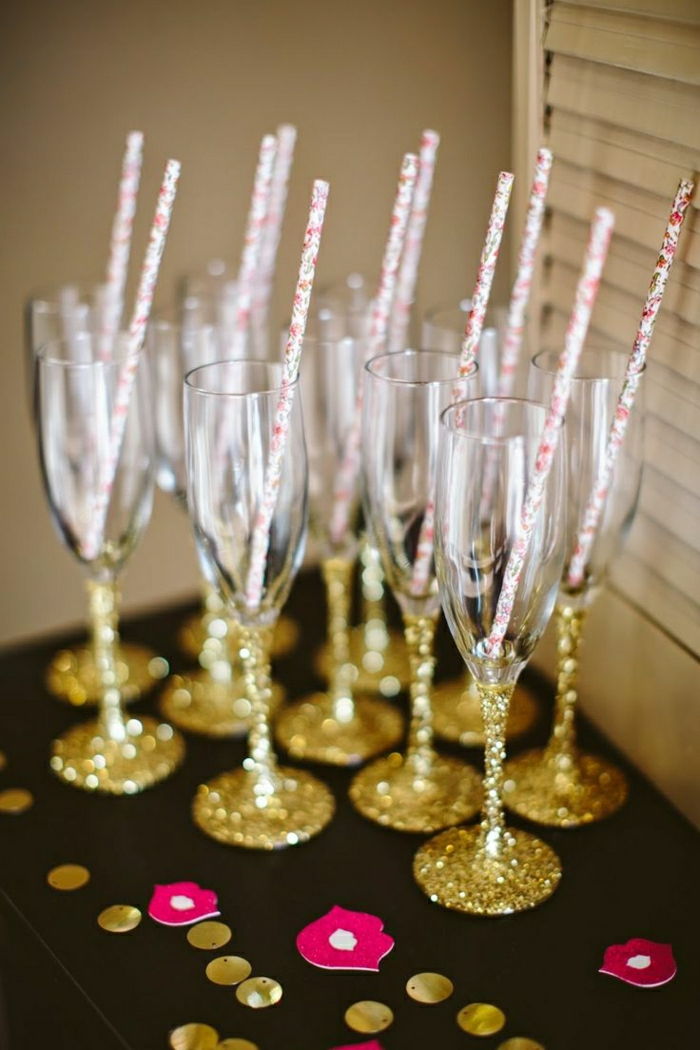 Vidros de Champagne e ouro-brilho colorido das palhas