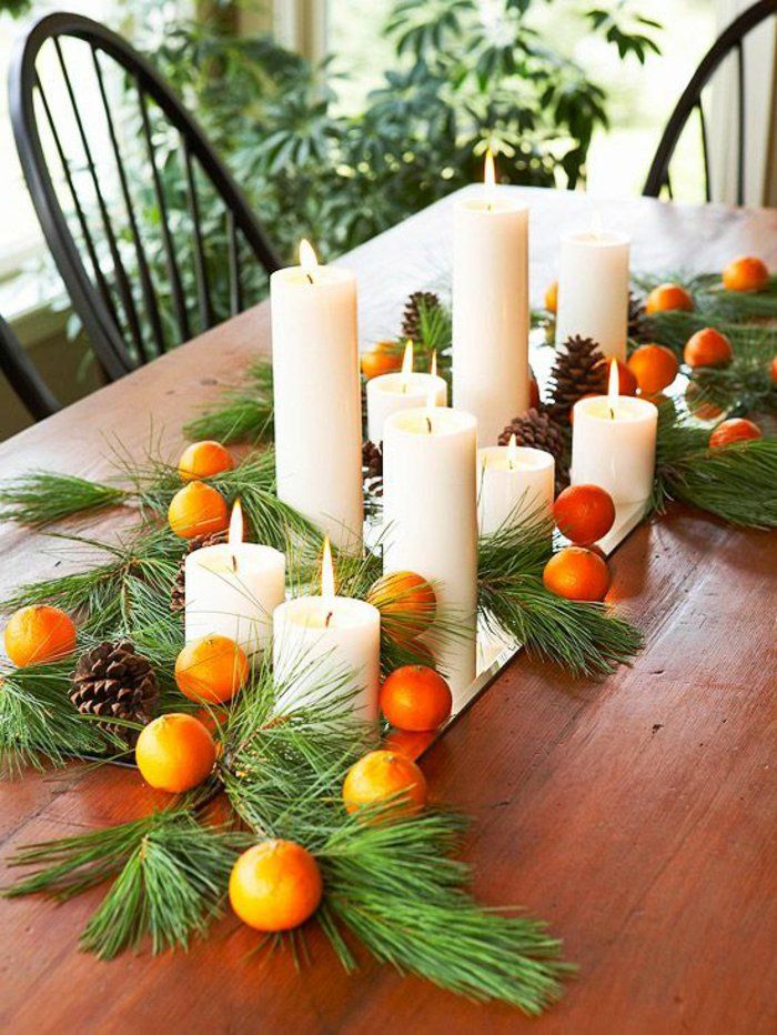 Tischdeko till jul Zannenzweige och orange kottar ljus