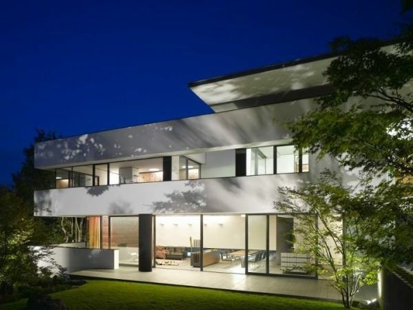 Düz çatı ve cam duvarlı beyaz ev modeli