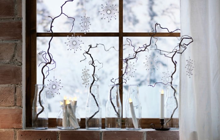 Štyri suché konáre umiestnené v sklenených fľašiach, tri umelecké sviečky v sklenených vázach, vence hobby papiera snehové vločky, dlhé biele opony tylu, domu s tehlovou múr, staré okná s rámami z dreva