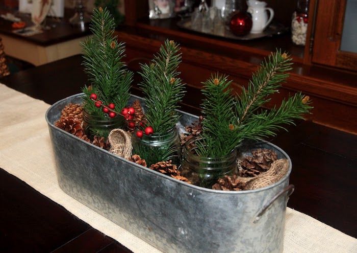 Kalėdų išdėstymas trijų masono indų, pilnas eglių šakų ir alavo su kūgiais