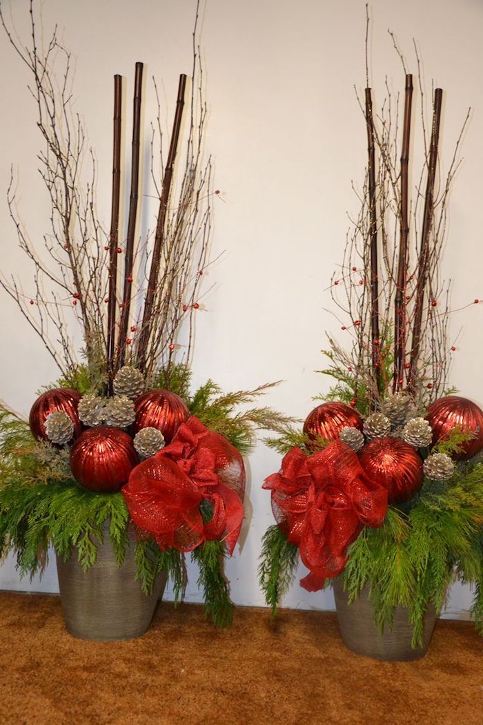 två blomkrukor med stora röda julbollar och små grenar, stora pinnar - jularrangemang