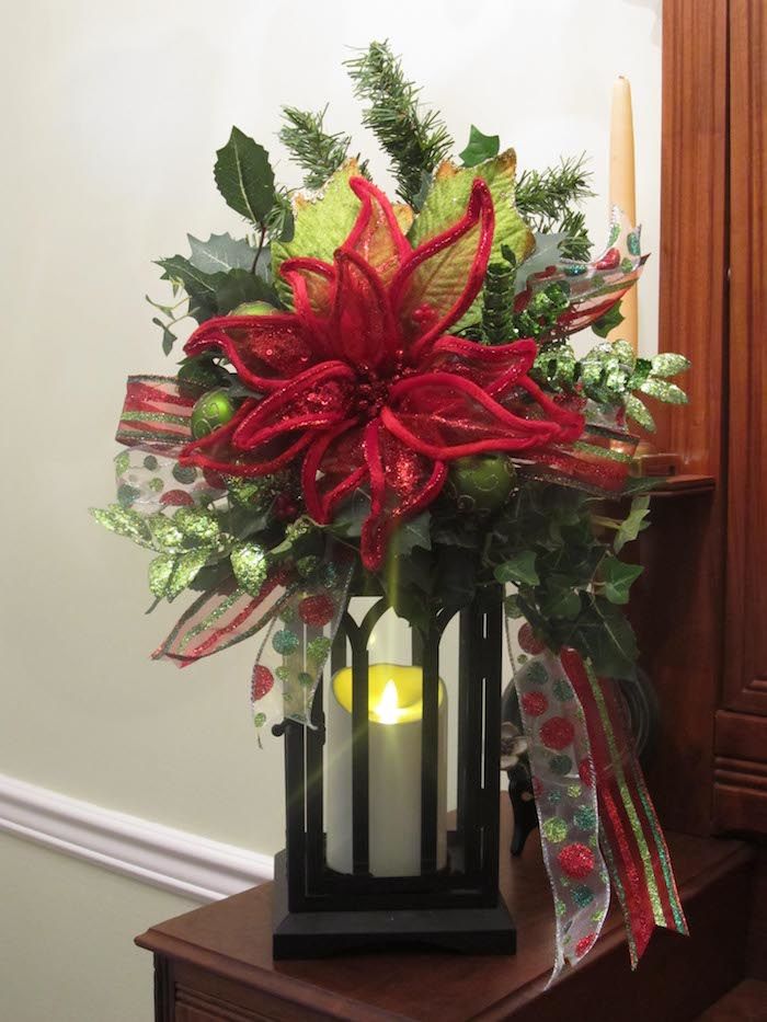 en lykta med ett ljus, en röd blomma och gröna grenar, färgglada båge - Juldekorerade dörröppningar