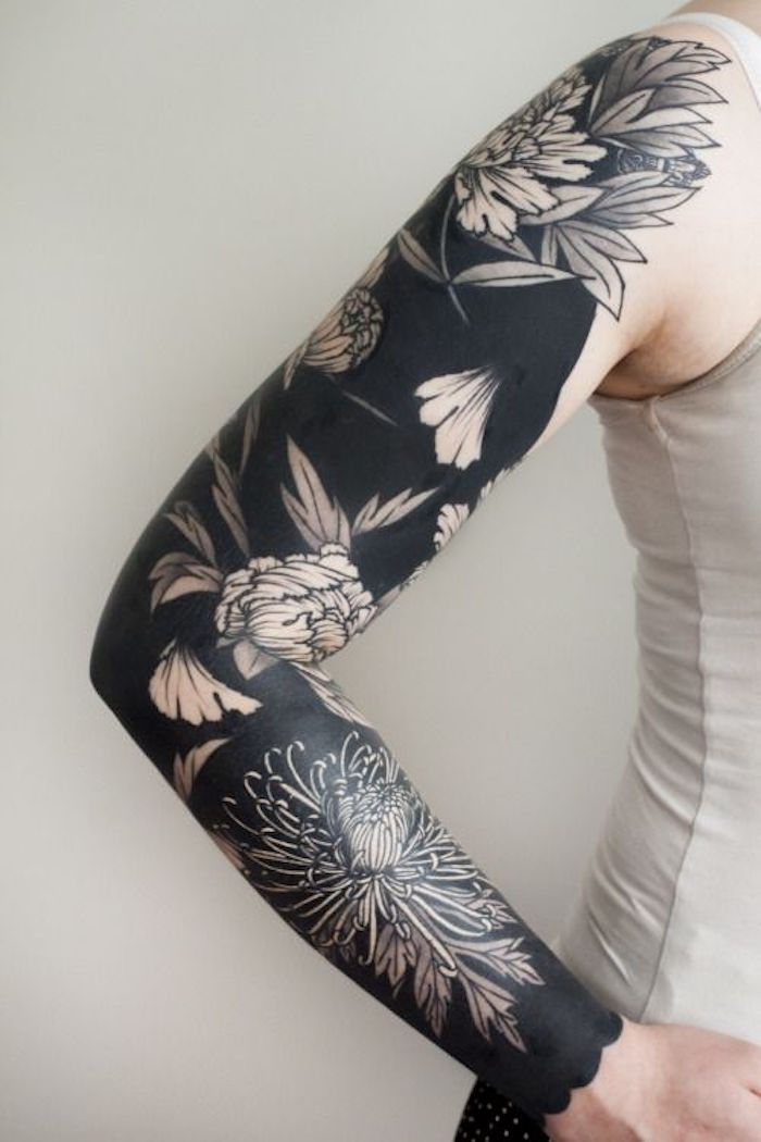 uma tatuagem preta inteira com flores em todo o braço - tatuagem blackwork