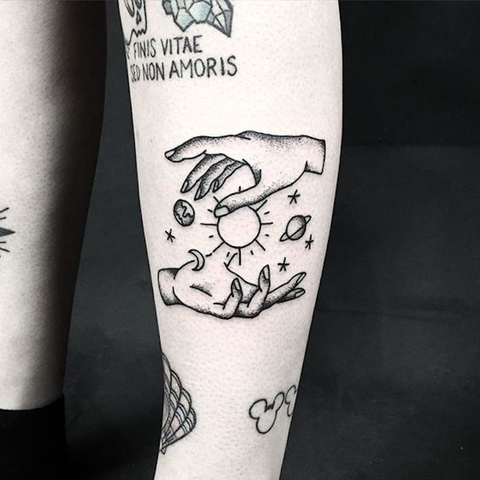 duas mãos do homem e da mulher com o sol e os planetas entre tatuagem blackwork