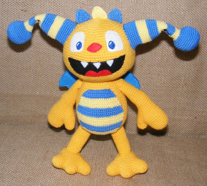 o creatură ciudată, în culoarea galbenă și albastră, cu gura deschisă - farmecul norocului de croșetat