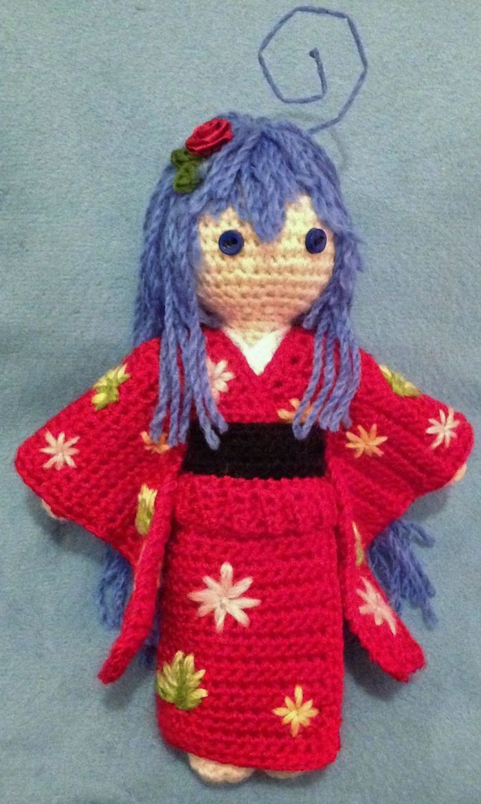 japonská bábika vyrobená z anime, fialové vlasy a červené šaty s ružou