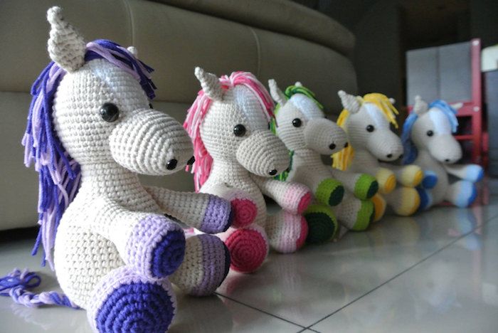 cai colorați aranjați într-un rând cu mane în diferite culori - model Amigurumi croșetat