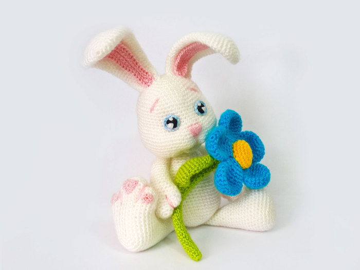 la croșetat pentru Paște, un iepure de Paști în culoare albă, cu o floare albastră