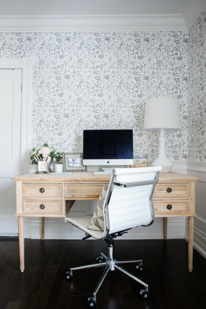 Table din lemn masiv, scaun cu rulouri, lampă de noptieră albă, tapet alb cu amprente florale