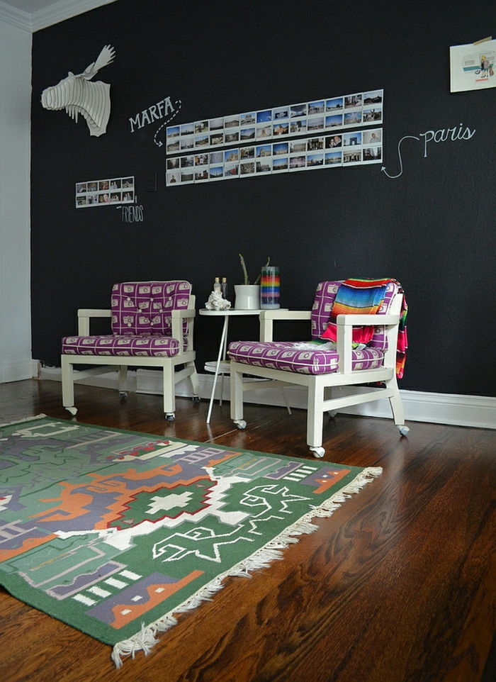 Mobilier de studiu, scaune albe din lemn cu perne violete, covor colorat, perete cu vopsea de tablă, fotografii pe perete