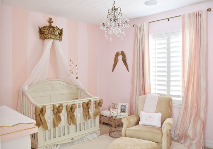 Vaikų kambarys mažoms princesėms, vaikiška lovelė su danga, vainiku ir kaspinu, rožinės sienos, žaisminga liustra