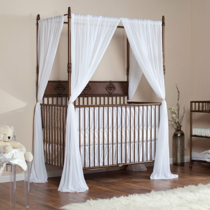 Medinė lova su baltu dangumi, natūrali mediena, linksma kėdė ant kėdės, pastelinių spalvų kūdikių kambarys