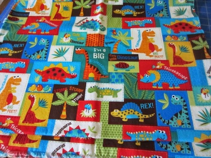 et originalt kreativt patchwork teppe med mange små dinosaurer - så morsomt