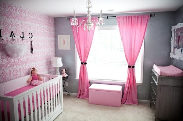 cortinas rosadas e lustres de vidro no quarto do bebê