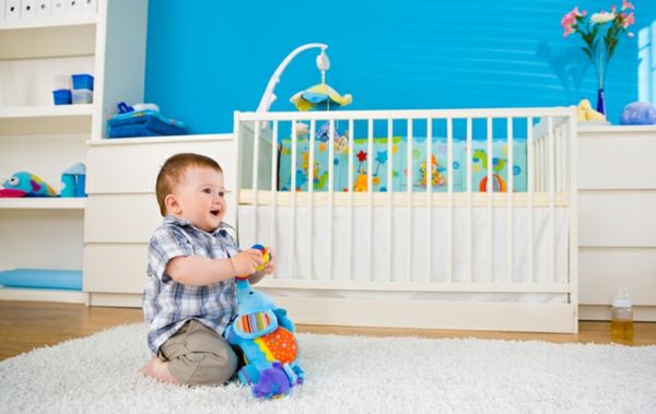 babyroom-young-sweet-baby-on-the-floor-vit-barnsäng