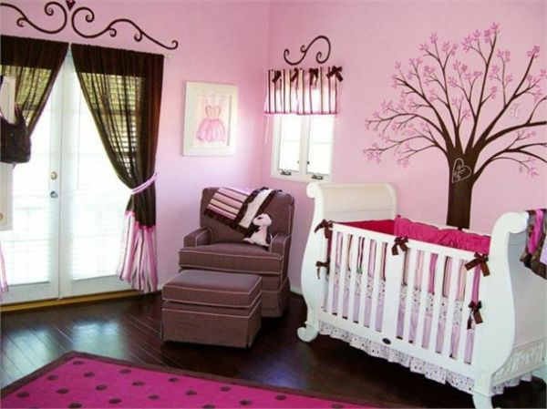 Pintura de árvore na parede na sala do bebê rosada