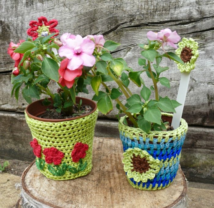 cvetlični lončki okrasijo cvetlični pokrov, ki pokriva pletenje modro zelenega roza rdečega lesa