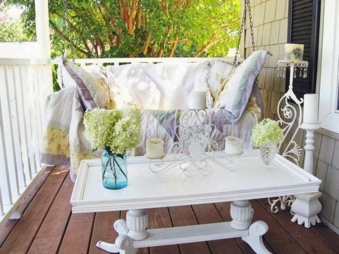 balcon de design balansoar-alb-dormit-Lumânări-lemn podea pătură albă-perne-masă alb-flori vaze-