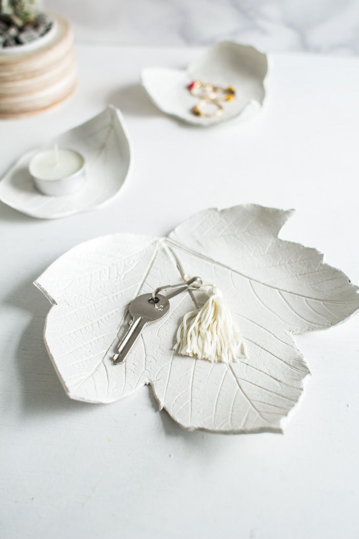 vit skål med lera i form av blad, skål, ringar, smyckeskål, teljus, teljushållare