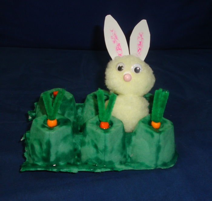 Pudełko z jajkami reprezentuje ogród, w którym króliczek wielkanocny wybiera marchewkę
