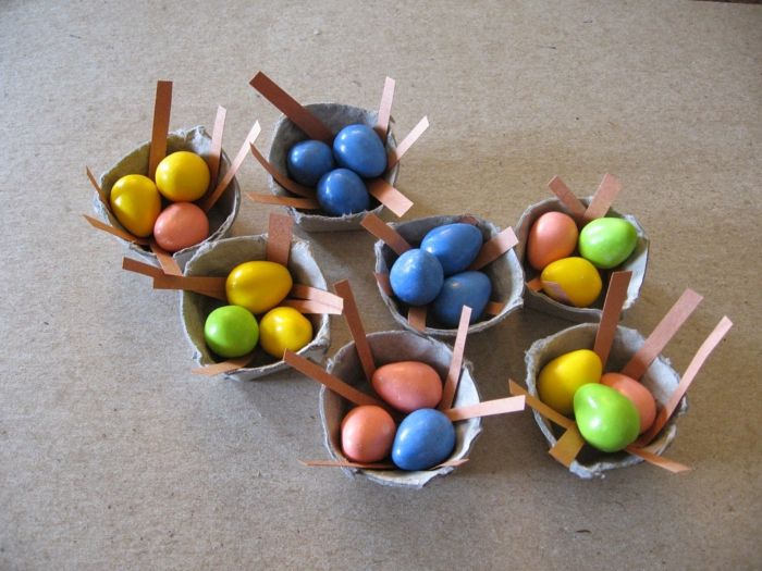 Kleine mand met eierdoos Pasen chocolade-eieren in vele kleuren